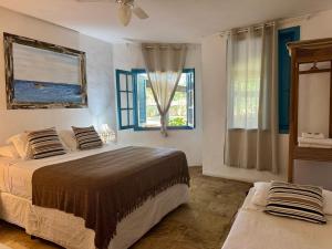 a bedroom with two beds and a window at Peixe Crew Manguinhos in Búzios +78 photos
