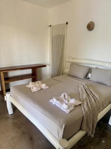 a bedroom with a bed with towels on it at Pousada Villa Jodie in Fortim