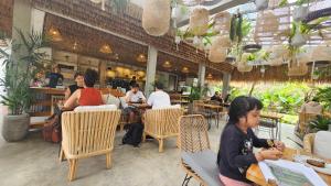 a group of people sitting at tables in a restaurant at Ubud Paradise Villa in Ubud