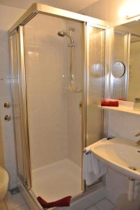 a shower with a glass door next to a sink at AKZENT Hotel Am Bach in Dettelbach