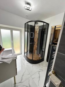 a bathroom with a large glass shower in a room at Le Petit Quiou in Le Quiou