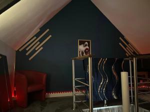 a room with a dark blue wall and a chair at Le Petit Quiou in Le Quiou