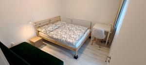 a small bedroom with a bed and a chair at Vila Kele in Tvrdošovce