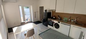 a kitchen with a sink and a washer and dryer at Vila Kele in Tvrdošovce
