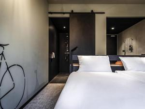 two white beds in a room with a door at Hotel Valkenburg by Mercure - Next to Shimano Experience Center in Valkenburg +73 photos