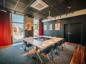 a conference room with a large table and chairs at ibis Styles Lens Centre Gare in Lens