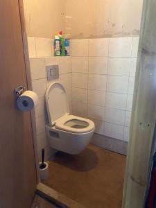 a bathroom with a toilet with the lid up at Belmont-chambres 