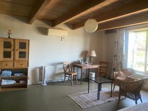 a living room with a table and chairs and a desk at Belmont-chambres 