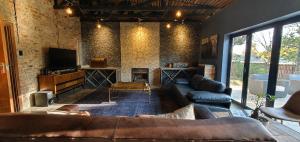 a living room with a couch and a tv at Le Grant Guesthhouse in Kroonstad