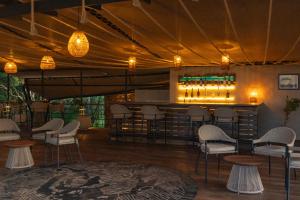 a bar with chairs and a counter with wine bottles at Surana Mara Camp in Mara Simba