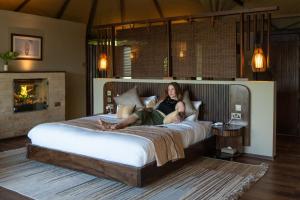 a woman laying on a bed in a bedroom at Surana Mara Camp in Mara Simba +13 photos