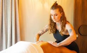 a woman with tattoos sitting on a bed at Surana Mara Camp in Mara Simba