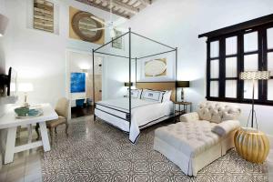a bedroom with a bed and a couch and a table at Casas del XVI in Santo Domingo