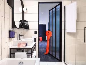 a bathroom with an orange umbrella in the doorway at Tribe Paris La Defense Esplanade in Courbevoie