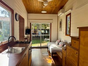 a kitchen with a sink and a bed in a room at Peixe Crew Manguinhos in Búzios