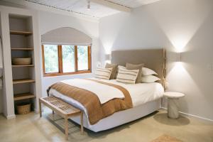 a white bedroom with a bed and a window at The Oak Cottage in Wellington +16 photos