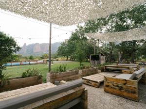 a patio with wooden tables and a white canopy at Camping Armalygal in Murillo de Gállego