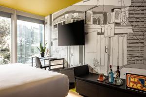 a bedroom with a bed and a wall mural at Play Midtown Hotel Tel Aviv in Tel Aviv
