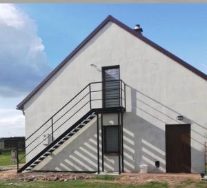 a white building with stairs on the side of it at Apartament 2-pokojowy, z atrakcjami dla dzieci in Kolonia Salnia