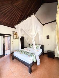 a bedroom with a bed with a mosquito net at Badini Homestay Pemuteran Bali in Pemuteran +62 photos