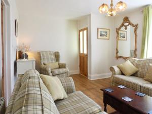 a living room with two couches and a table at Ferndene Cottage in Hinderwell