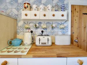a kitchen with a toaster and other appliances on a counter at Ferndene Cottage in Hinderwell