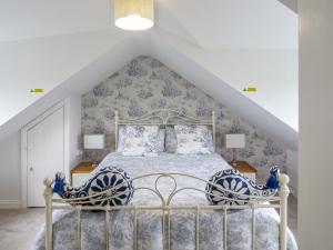 a bedroom with a bed with blue and white wallpaper at Ferndene Cottage in Hinderwell +12 photos