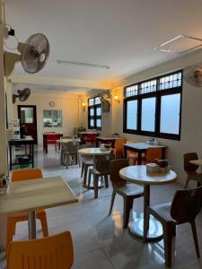 a restaurant with tables and chairs and windows at Mookboonchu Guesthouse ,Kohmook Trang in Ko Mook