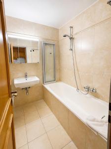 a bathroom with a bath tub and a sink at Haus am Anger Top 42 in Königsleiten