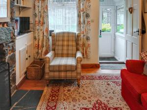 a living room with a chair and a couch at 1 Tower Cottage in Portinscale