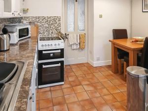 a kitchen with a stove and a counter top at 1 Tower Cottage in Portinscale +16 photos
