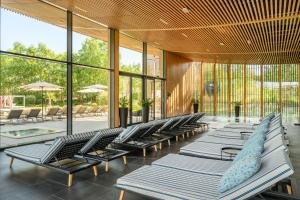 a row of lounge chairs in a building with windows at Evergreen Health Longevity Residence in Kehidakustány