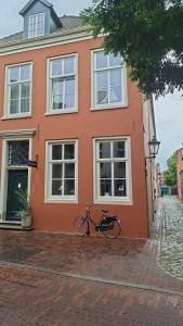 a bike parked in front of a orange building at Altstadt-Domizil 7 in Leer