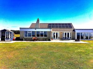 a house with solar panels on top of it at Driftwood in Mainsriddle