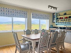 a dining room with a table and chairs and a kitchen at Driftwood in Mainsriddle