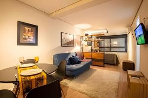 a living room with a couch and a table at Studio 907 Flow Live - Parque Una + garagem in Pelotas