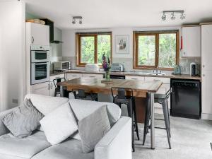a kitchen with a couch and a wooden table at Torridge Lodge - Ukc9517 in Sheepwash
