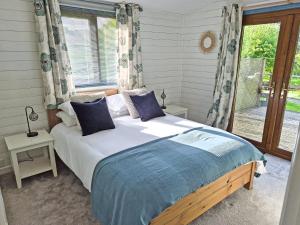 a bedroom with a large bed with a window at Torridge Lodge - Ukc9517 in Sheepwash
