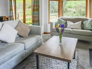a living room with two couches and a table with flowers at Torridge Lodge - Ukc9517 in Sheepwash