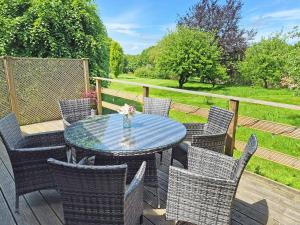 a patio with a table and chairs on a deck at Torridge Lodge - Ukc9517 in Sheepwash +11 photos