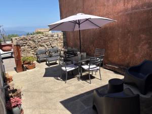 a table and chairs with an umbrella on a patio at Maravillosa casa con vistas al mar in Baiona
