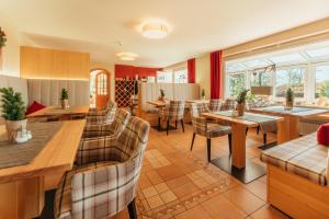 a dining room with tables and chairs and windows at Vitalhotel Sonneneck in Hohegeiß