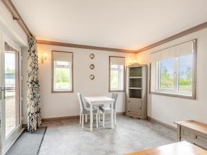 a dining room with a table and chairs and windows at Teal - Uk41036 in Marston