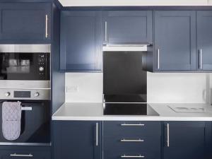 a kitchen with blue cabinets and stainless steel appliances at Teal - Uk41036 in Marston