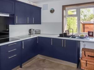 a kitchen with blue cabinets and a sink at Teal - Uk41036 in Marston