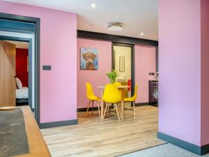 a dining room with a table and yellow chairs at The Hideaway in Yarmouth