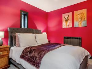 a bedroom with a red accent wall with a bed at The Hideaway in Yarmouth