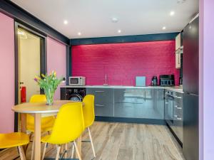 a kitchen with a table and yellow chairs at The Hideaway in Yarmouth