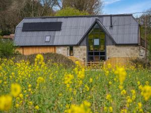 a barn with a field of flowers in front of it at The Hideaway in Yarmouth +10 photos