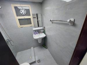 a bathroom with a sink and a toilet and a window at Friends Hotel Apartments in Ajman 